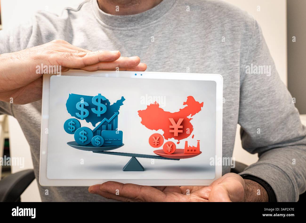 Man holding a tablet showing the trade imbalance between the US and China in the tariff war Stock Photo