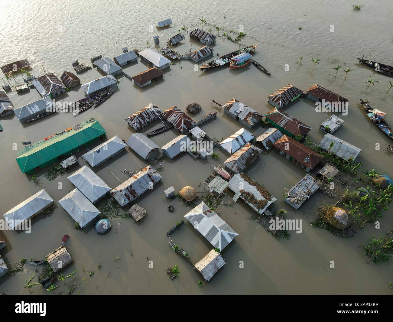 Aerial view of flooded homes and boats in a submerged village, Jatrapur ...