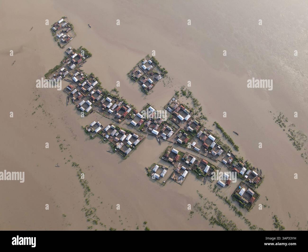 Aerial view of flooded village with submerged homes and boats, Jatrapur ...
