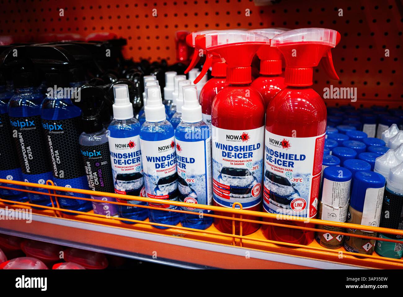 Kyiv, Ukraine - April 14, 2025: Various automotive windshield de-icer solutions showcased on metal shelves in a store Stock Photo
