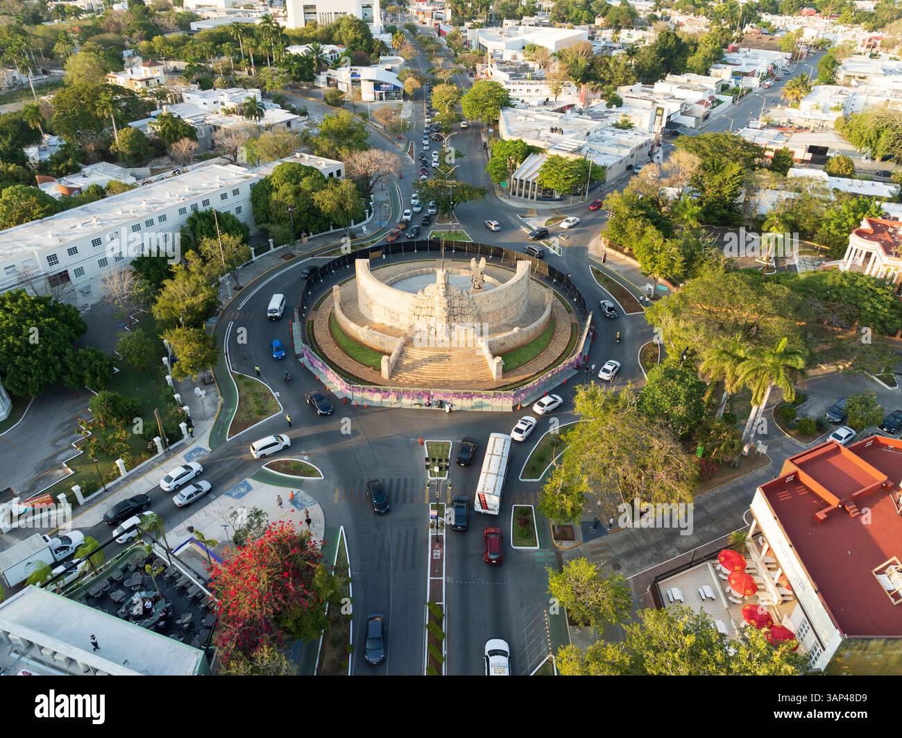 Aerial view of Paseo de Montejo, Monumento a la Bandera roundabout with traffic, trees, and shadows in evening, Merida, Yucatan, Mexico. Stock Photo