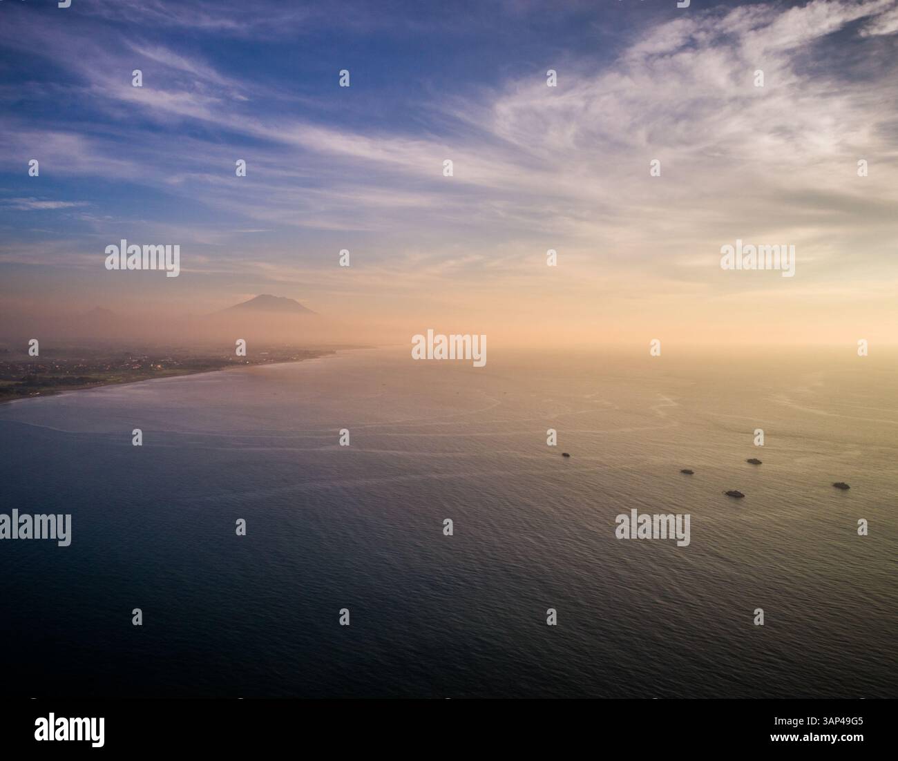 Aerial panoramic view of Bali Sea, yachts and coastal city at sunrise, Denpasar Selatan, Bali. Stock Photo