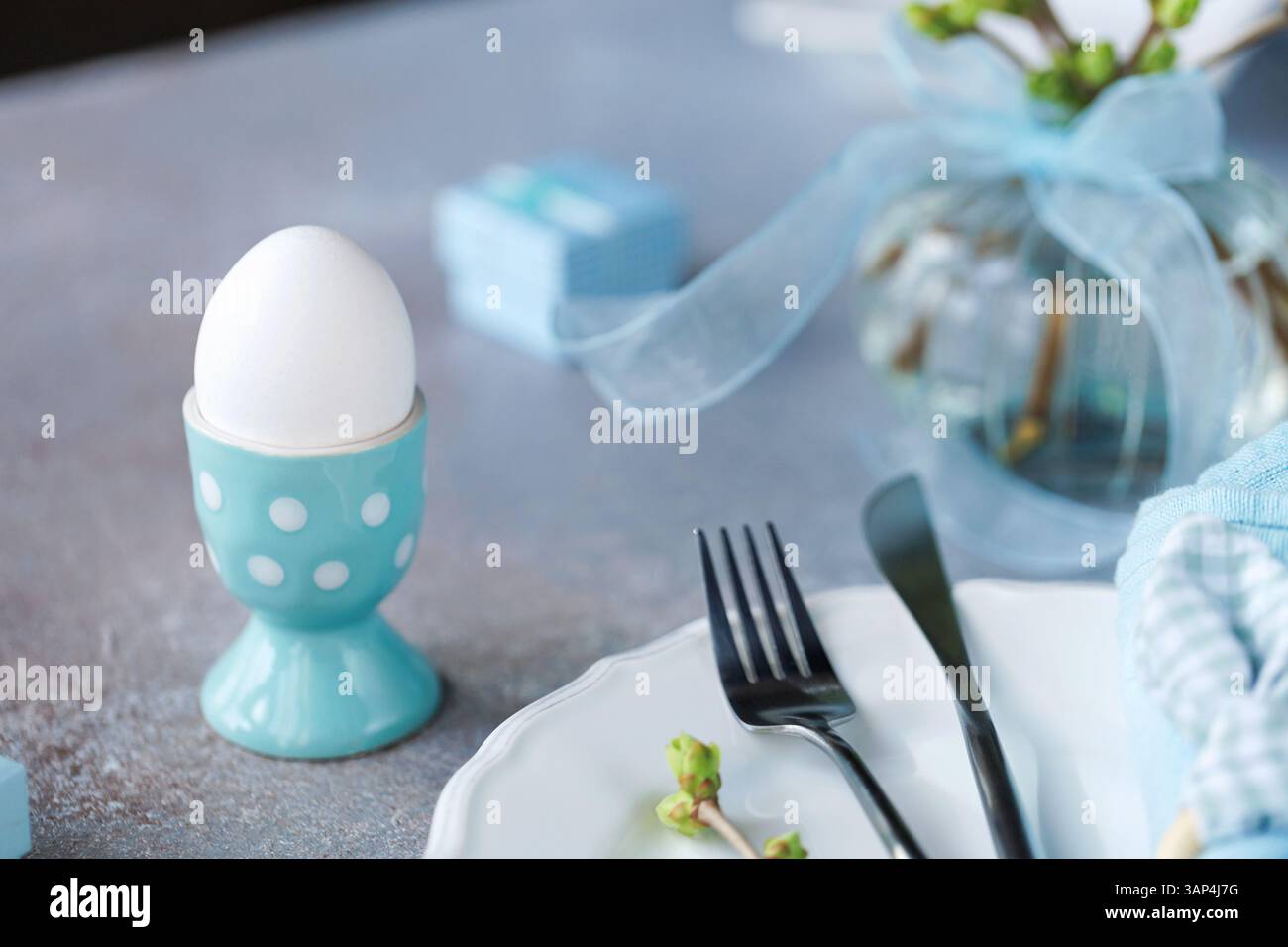 Easter Table Setting with Blue Napkin and Egg Stock Photo