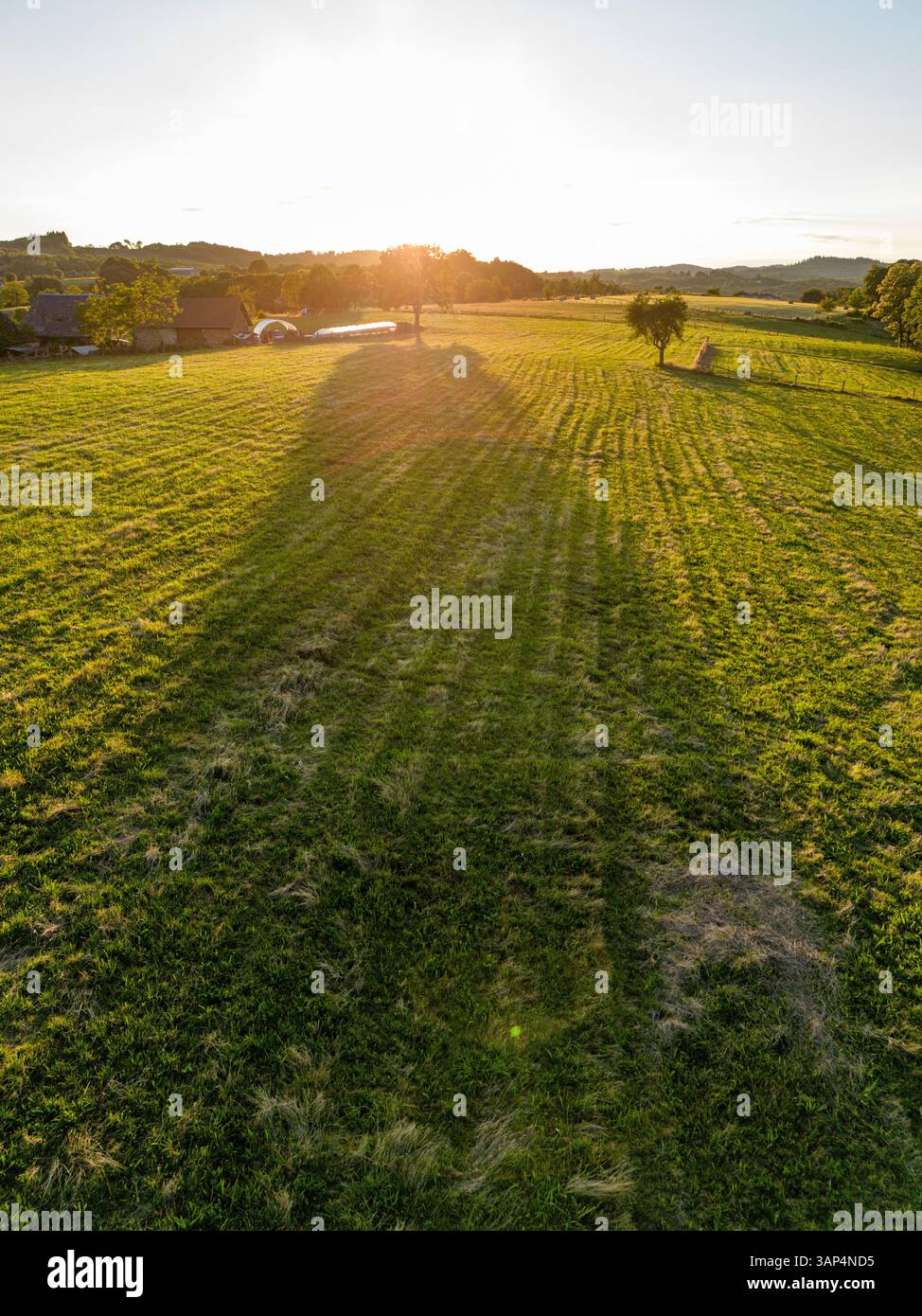 Aerial view of beautiful agricultural fields and tranquil trees under a serene sunset, Chenailler-Mascheix, France. Stock Photo