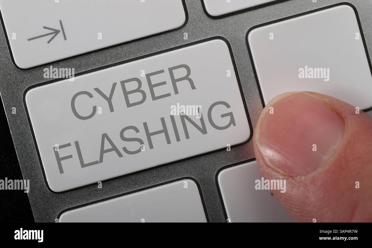 A man pressing Cyberflashing key on a computer keyboard. Stock Photo