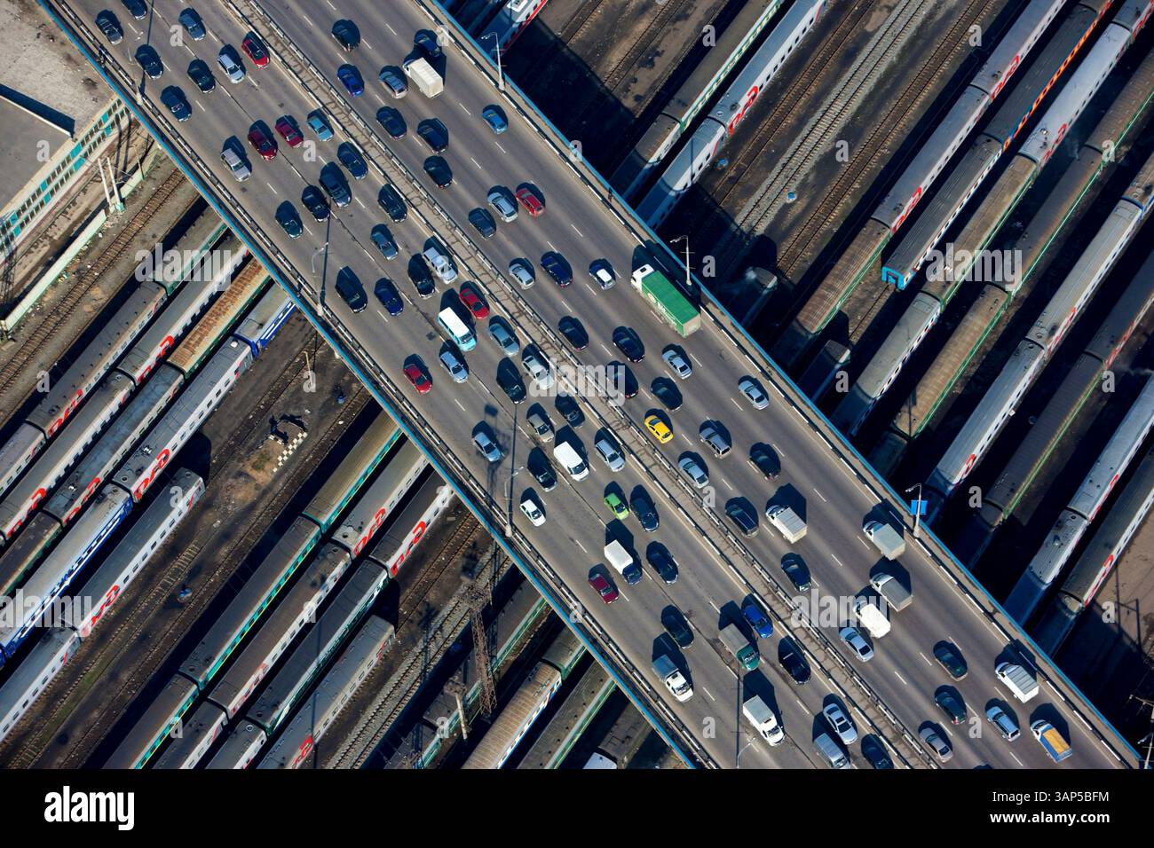 Aerial view of busy urban landscape with cars and trains on roads and ...