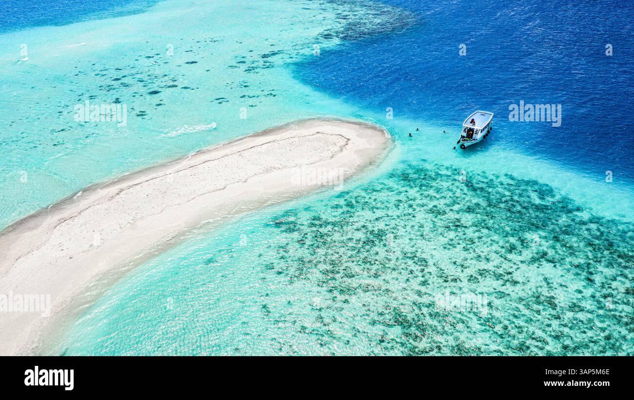 Aerial view of a sandbank, North Malé Atoll, Maldives, Indian Ocean with an anchored dhoni, boat and people swimmimg Stock Photo