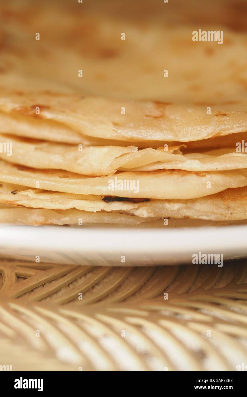 Delicious warm flatbreads stacked on a plate Stock Photo