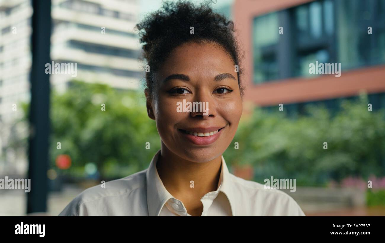 Happy African American woman looking at camera smiling toothy dental smile positive female girl businesswoman outdoor joyful portrait ethnic face Stock Photo
