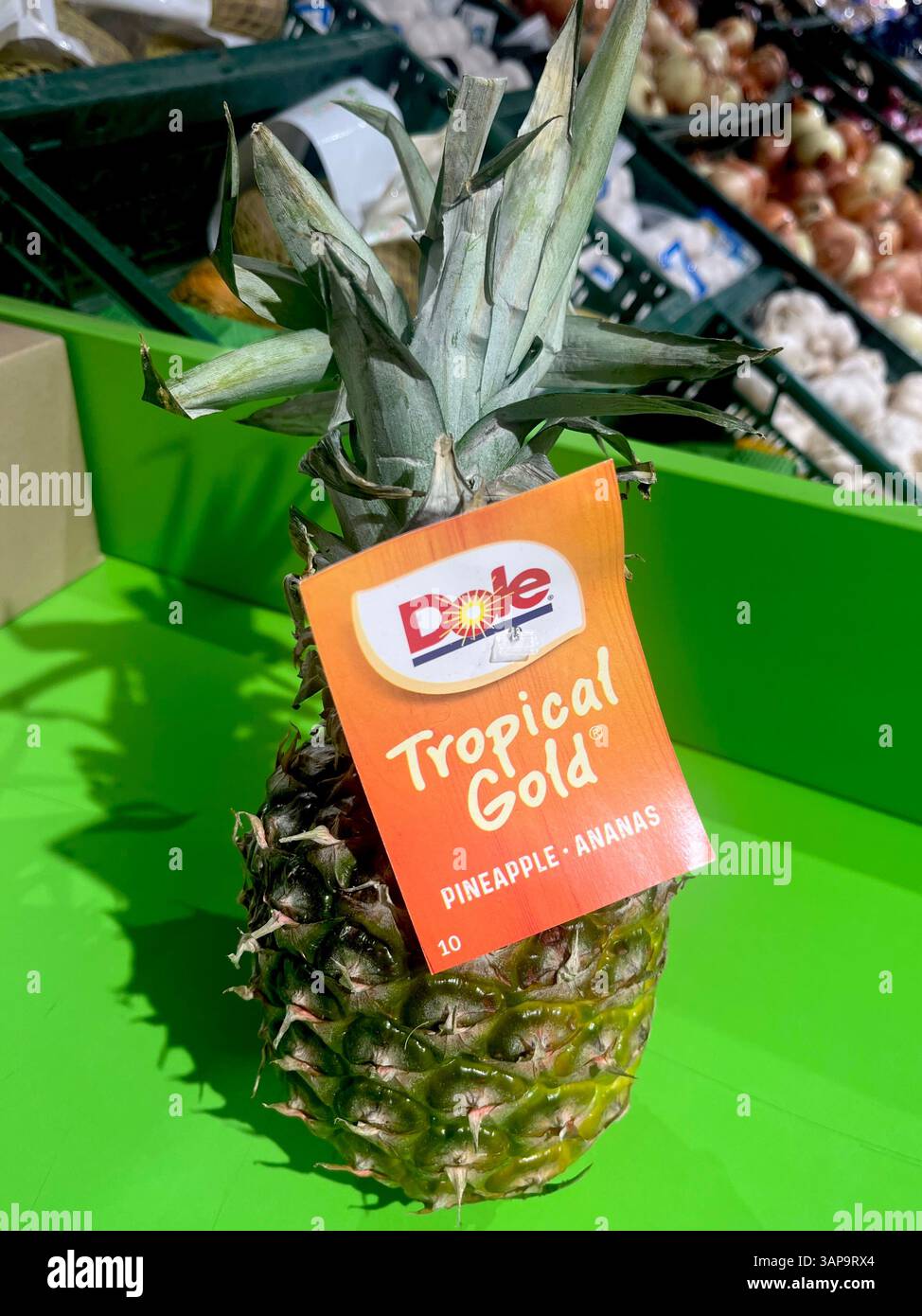 Dole Tropical Gold pineapple with branded label, ripe pineapple, ananas, supermarket, shopping, consumerism, fruits aisle, grocery store display - Smartphone Captured Stock Image