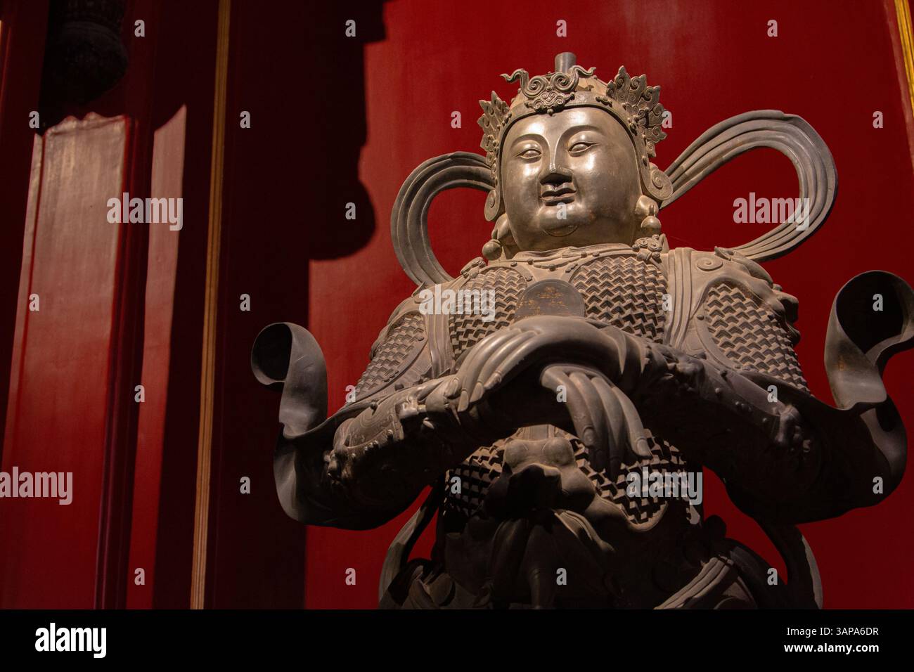 This is a cast Heavenly King, a guardian of Heaven. With a confident smile, he stands as a symbol of power and protection in Buddhist mythology. Stock Photo