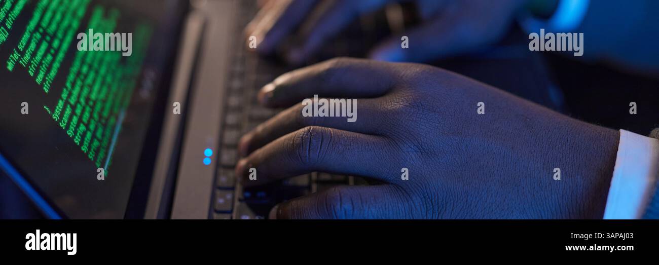 Website header shot of hands typing on a laptop keyboard with green code displayed on screen, emphasizing technology and coding process Stock Photo