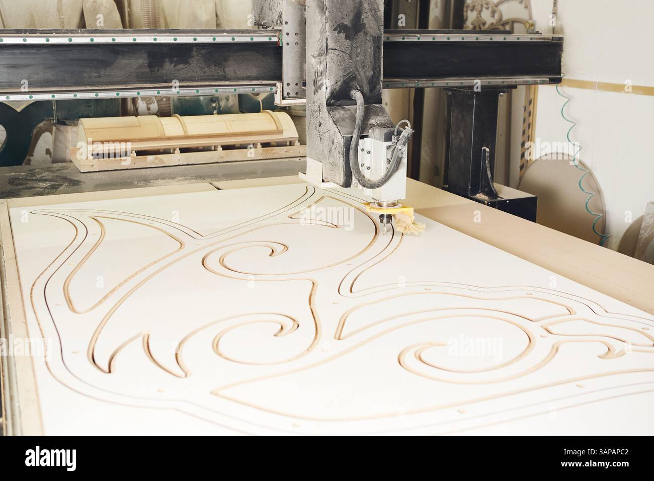 Numerically controlled woodworking machine cuts rounded complex lines on the canvas. Computer numerical control. CNC. Stock Photo