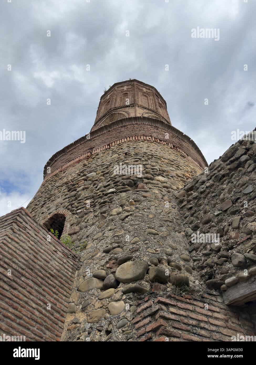Looking up Ancient stone tower under sky with clouds. Sighnaghi fortress, Kakheti region, Georgia - Smartphone Captured Stock Image