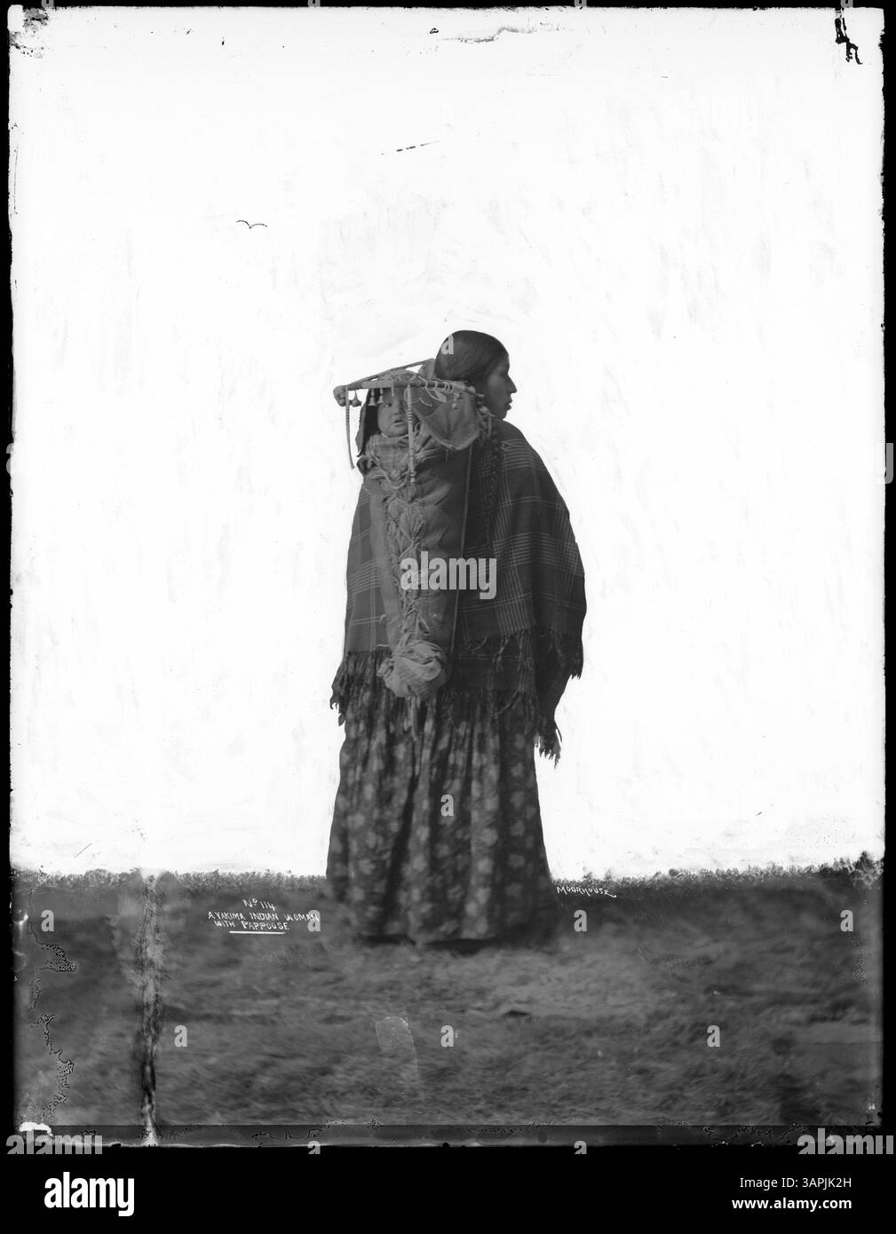 This photograph captures a Native American woman with a papoose, created with an intensified negative technique, providing a historic portrayal of Native American life. Stock Photo