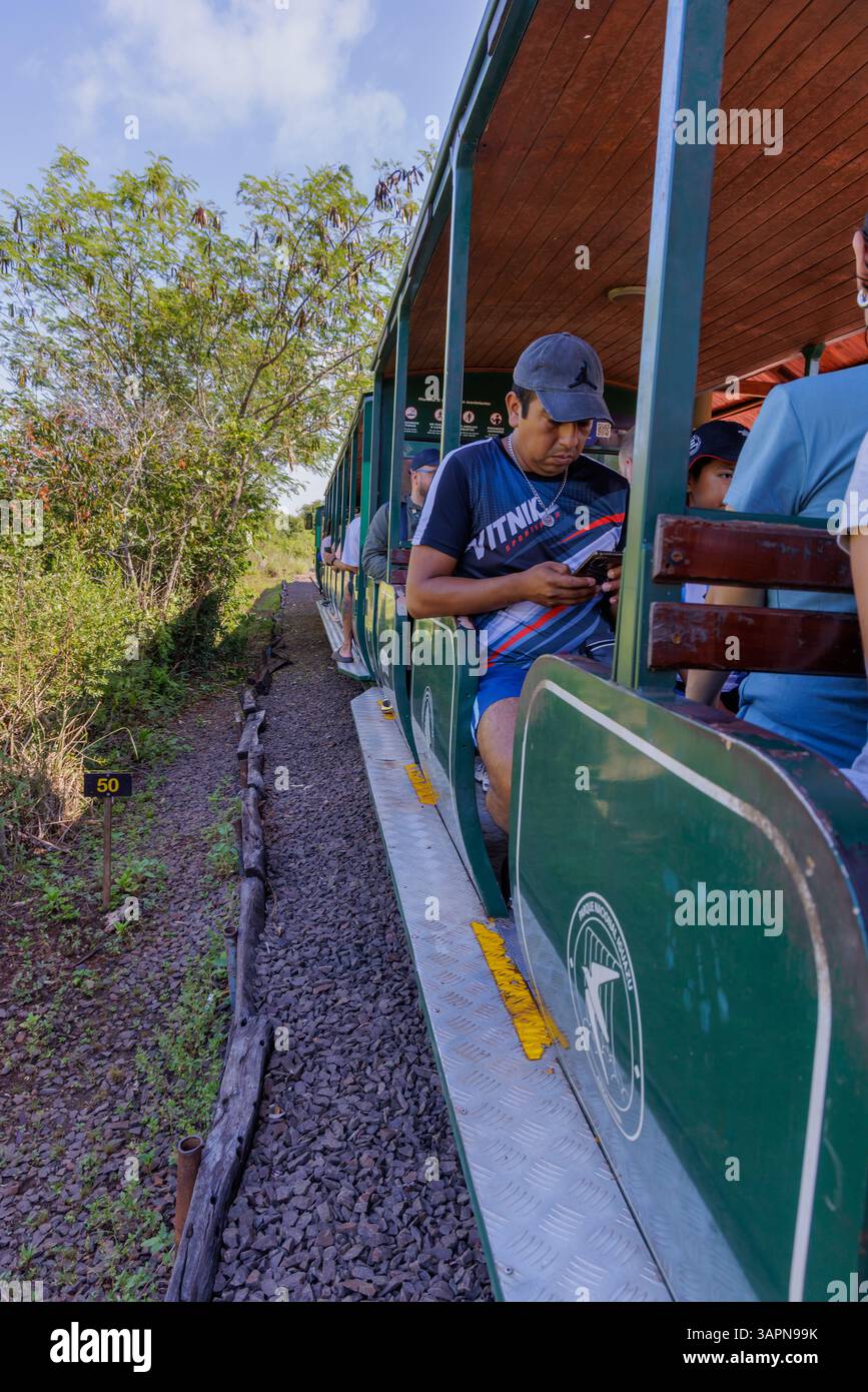 Puerto Iguazu, Misiones, Argentina - April 5th, 2025: Tourists traveling by train in Iguazu National Park. Stock Photo