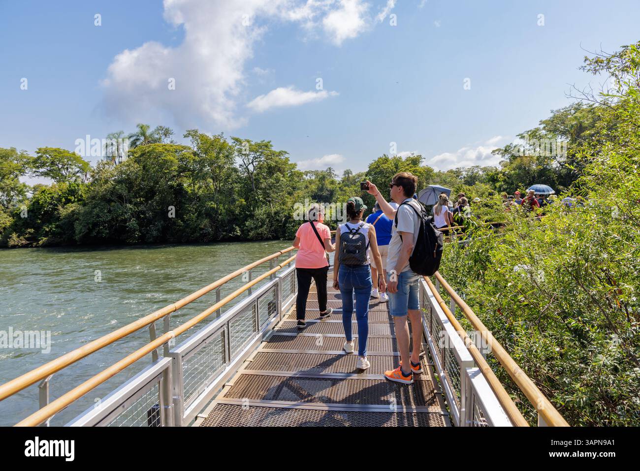 Puerto Iguazu, Misiones, Argentina - April 5th, 2025: Tourists trucking along the Iguazu Falls walkways. Stock Photo