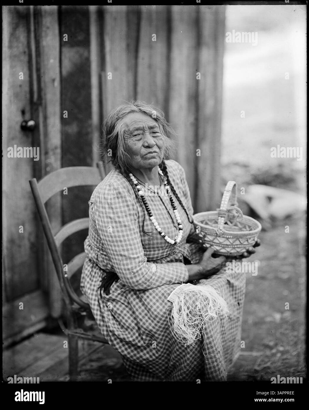 A black-and-white photograph of an old Native American woman sitting on ...