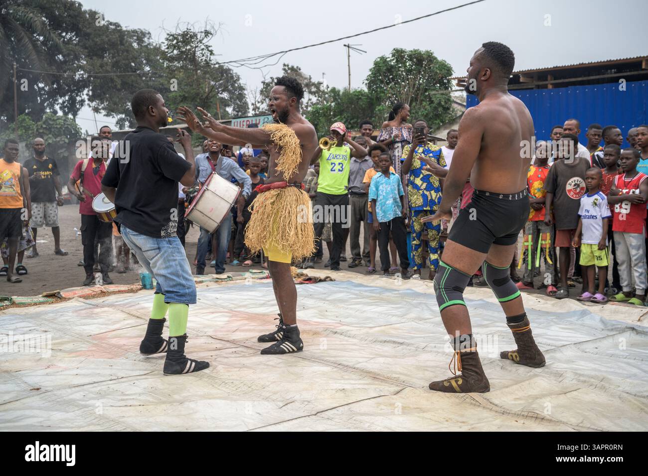 Catch Congolese wrestlers engage in a match on a makeshift ring in the streets of a Kinshasa suburb. Stock Photo