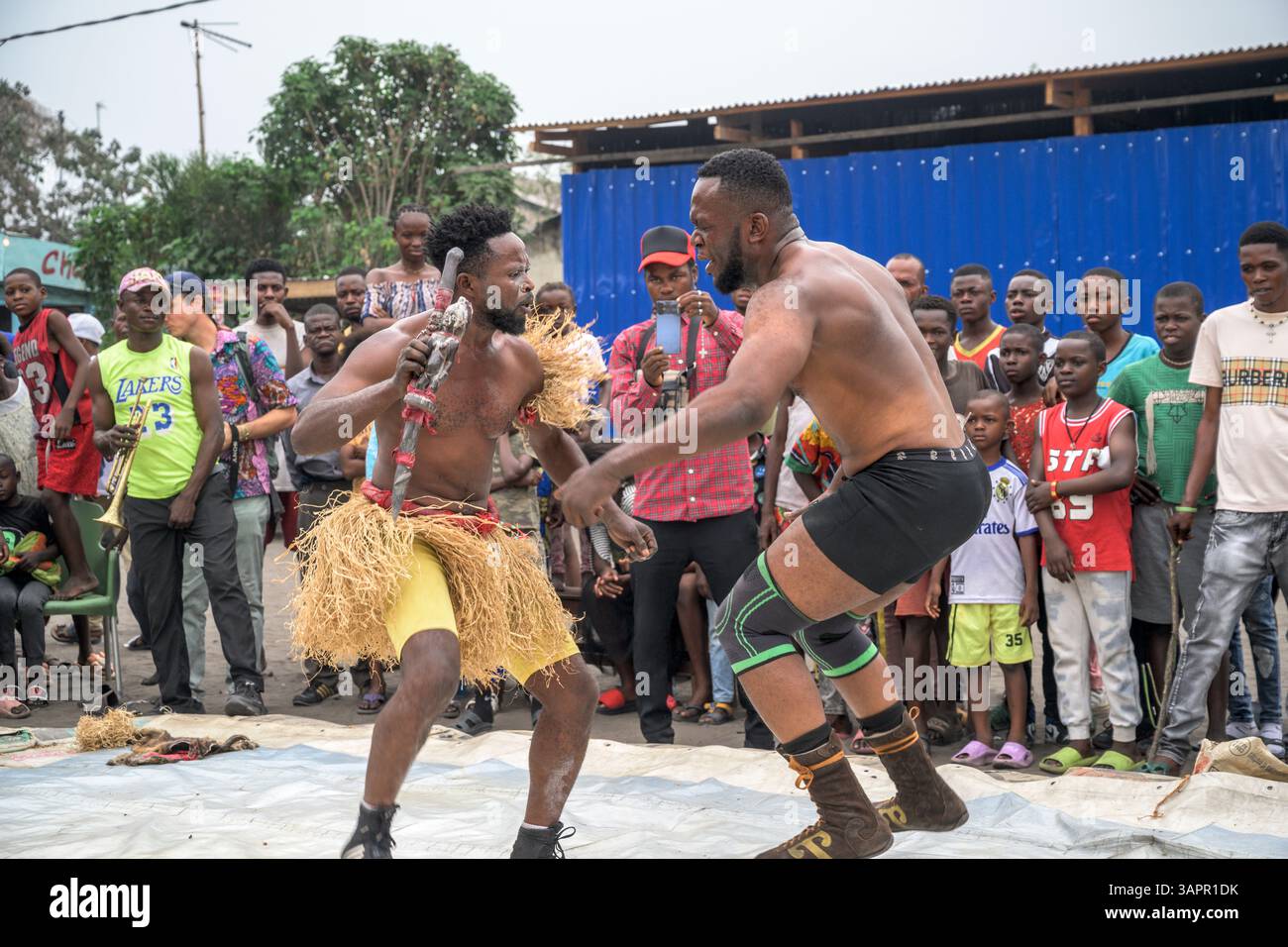 Catch Congolese wrestlers engage in a match on a makeshift ring in the streets of a Kinshasa suburb. Stock Photo