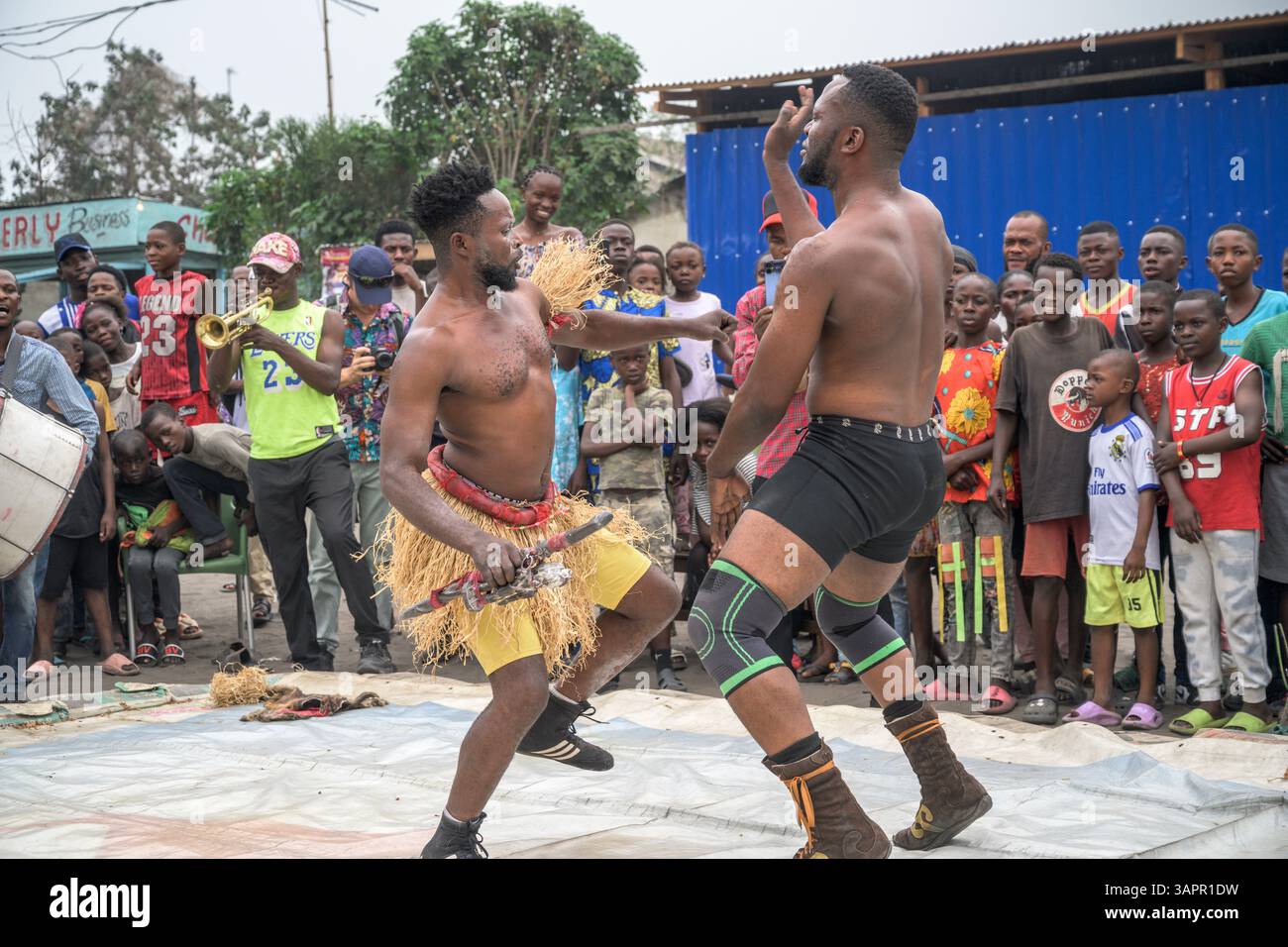Catch Congolese wrestlers engage in a match on a makeshift ring in the streets of a Kinshasa suburb. Stock Photo