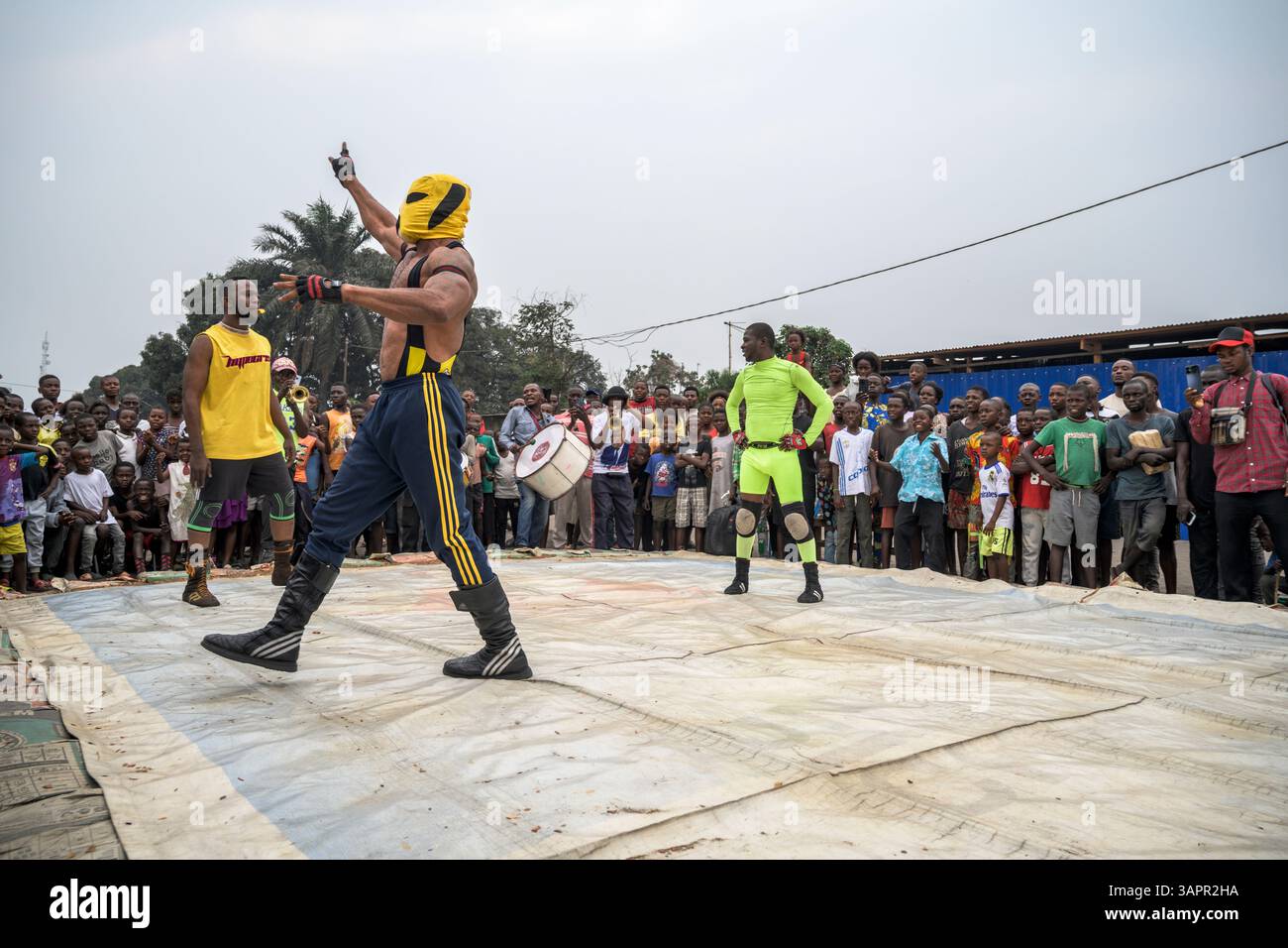 Catch Congolese wrestlers engage in a match on a makeshift ring in the streets of a Kinshasa suburb. Stock Photo