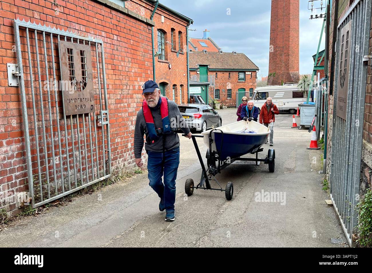 Two gentleman hauling a rowing boat from Underfall Yard up the narrow path towards Avon Crescent. Bristol, England, United Kingdom. 26th March 2025. - Smartphone Captured Stock Image