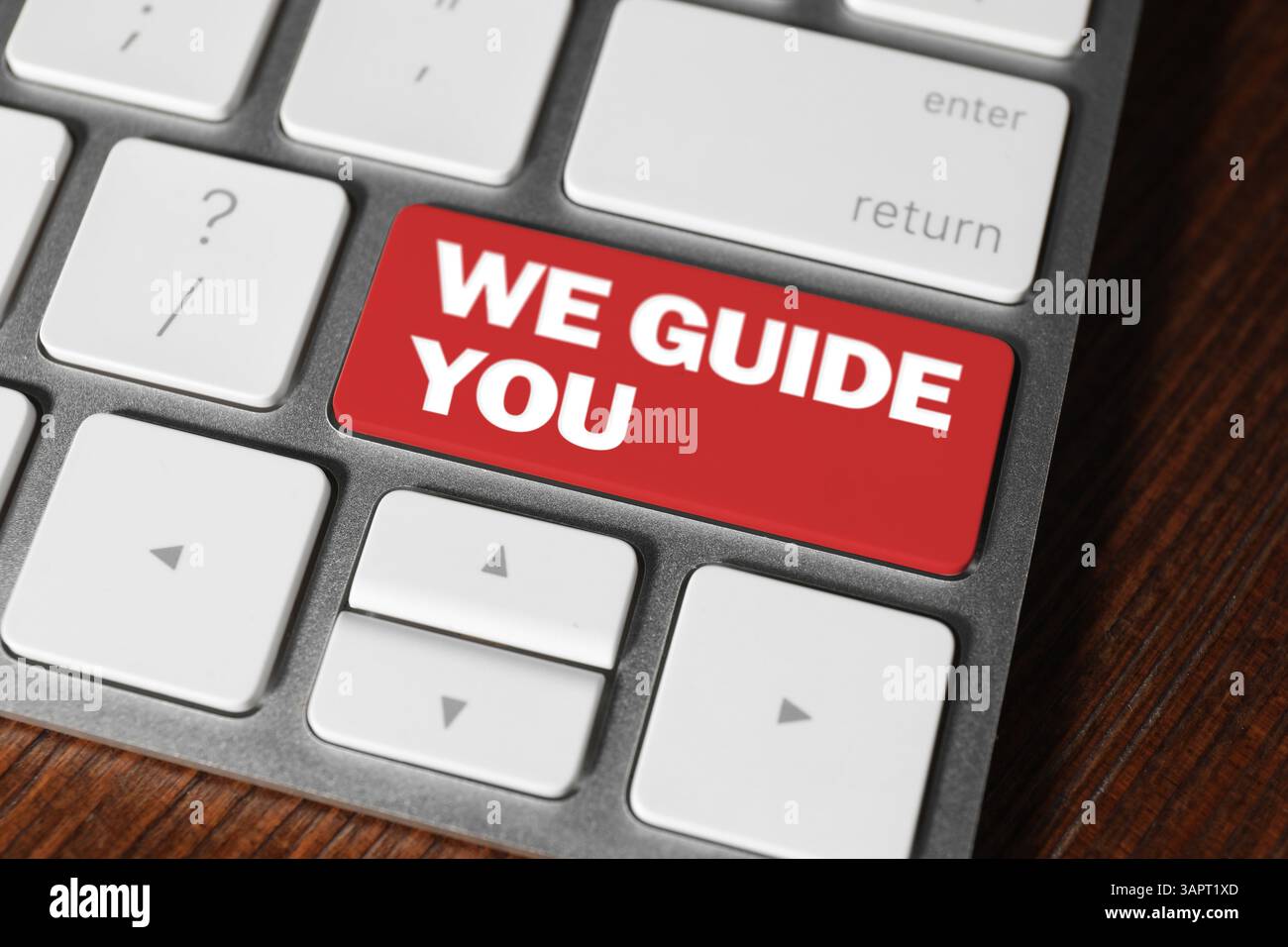 Red button with text We Guide You on computer keyboard, closeup Stock Photo