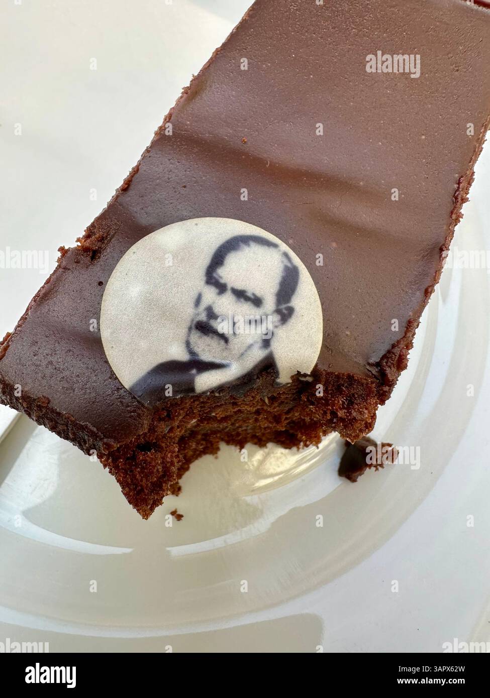 Eating a sacher cake with an image of Sigmund Freud in the Freud museum in Vienna - Smartphone Captured Stock Image