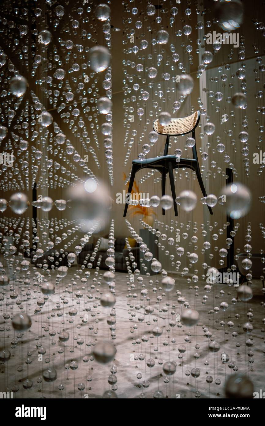 Artistic photo of a chair floating within a cascade of transparent hanging spheres Stock Photo