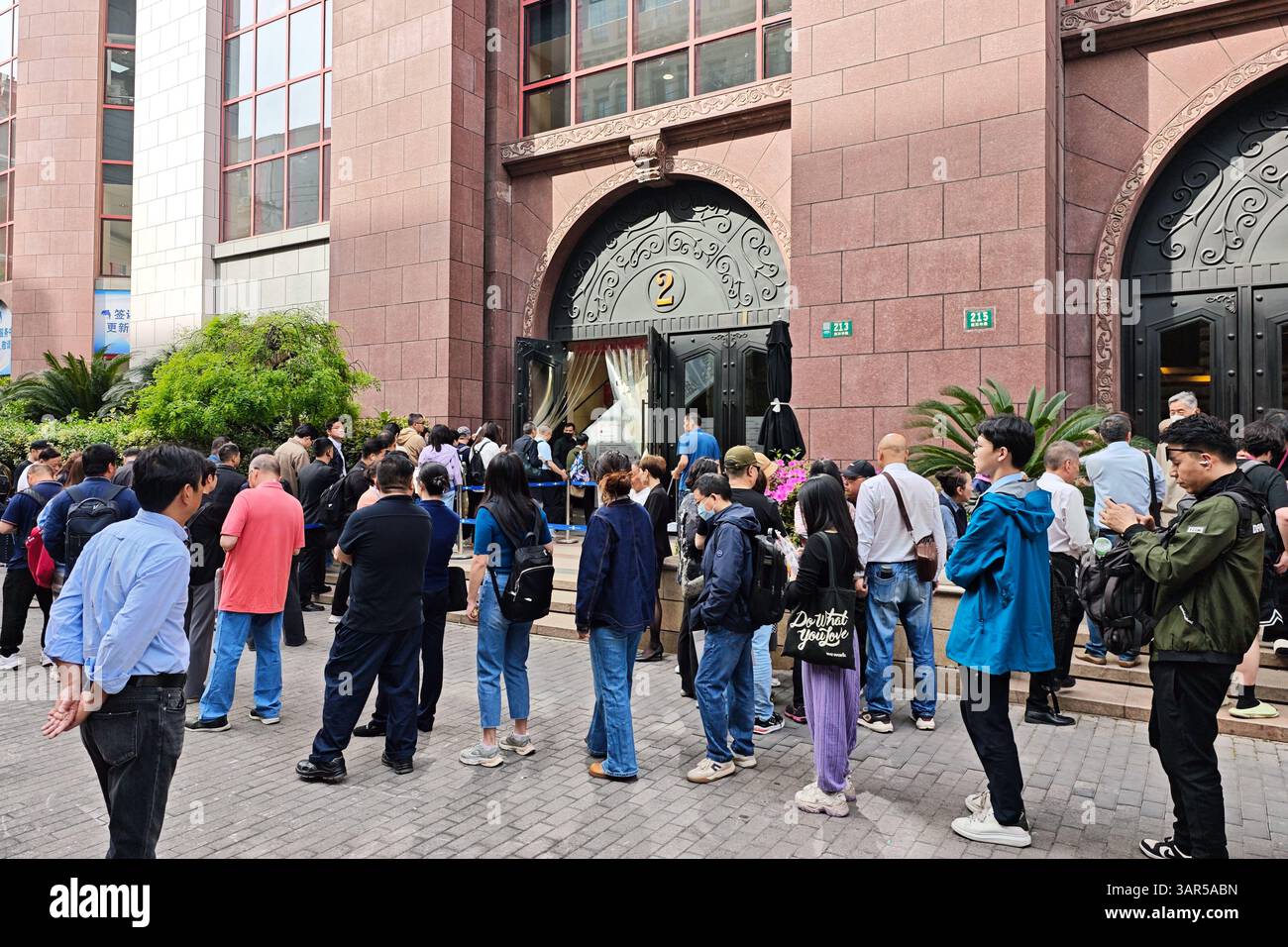SHANGHAI, CHINA - APRIL 17, 2025 - People line up in front of a visa ...