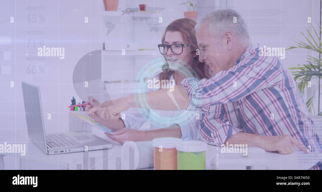 Image of diverse data and clock over caucasian female and male colleagues working at computer Stock Photo