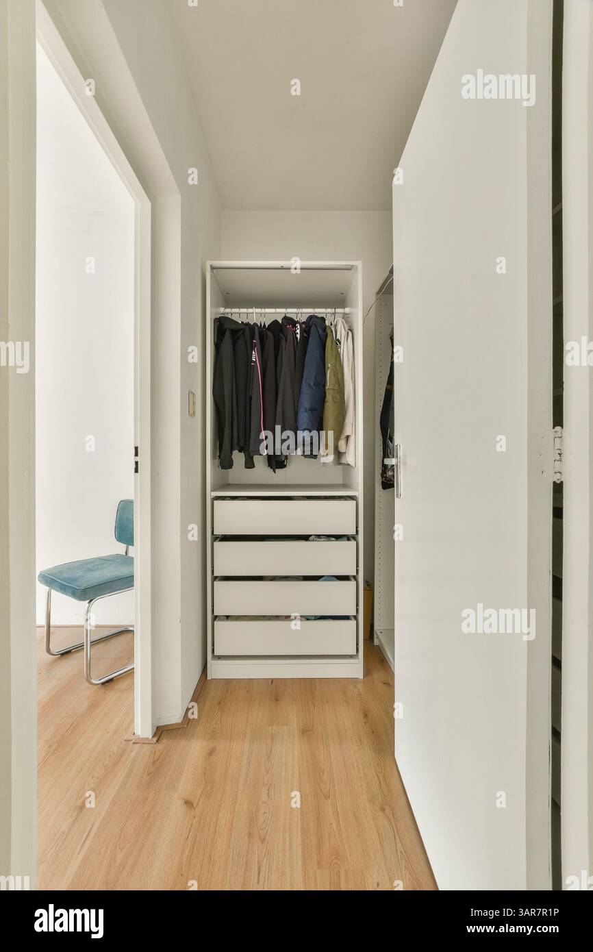 A tidy and modern interior featuring a wardrobe with clothes and a ... - Minimalist Swedish Wardrobe Design