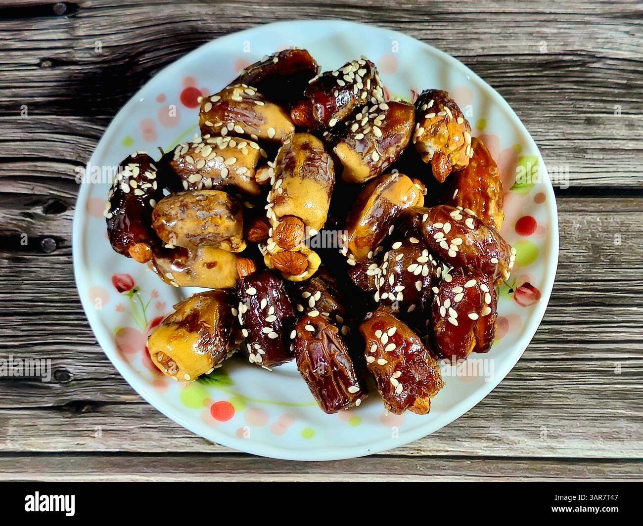 Dates fruit stuffed with almonds and nuts and topped with sesame seeds ...