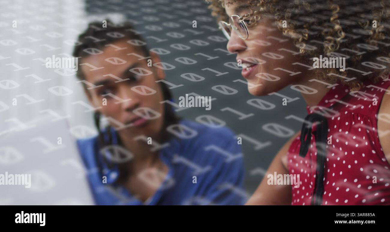 Image of binary coding over diverse business people using laptop Stock Photo