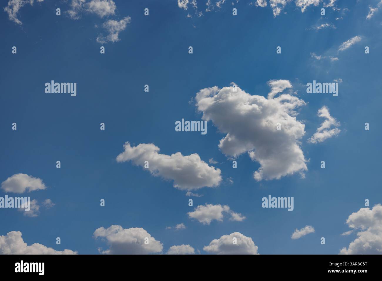 Peaceful sky with soft blue tones fluffy clouds—perfect natural background capturing serene beauty, open air, and calming atmosphere for visual escape Stock Photo
