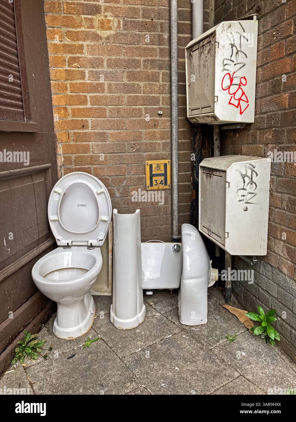 Found art: an old lavatory pan and cistern dumped by the roadside in a town in the UK - Smartphone Captured Stock Image