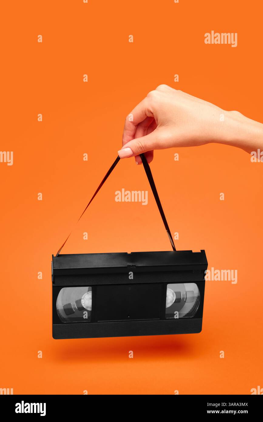 Vhs Ribbon Woman holding VHS tape by fragile magnetic ribbon like vintage handbag ...