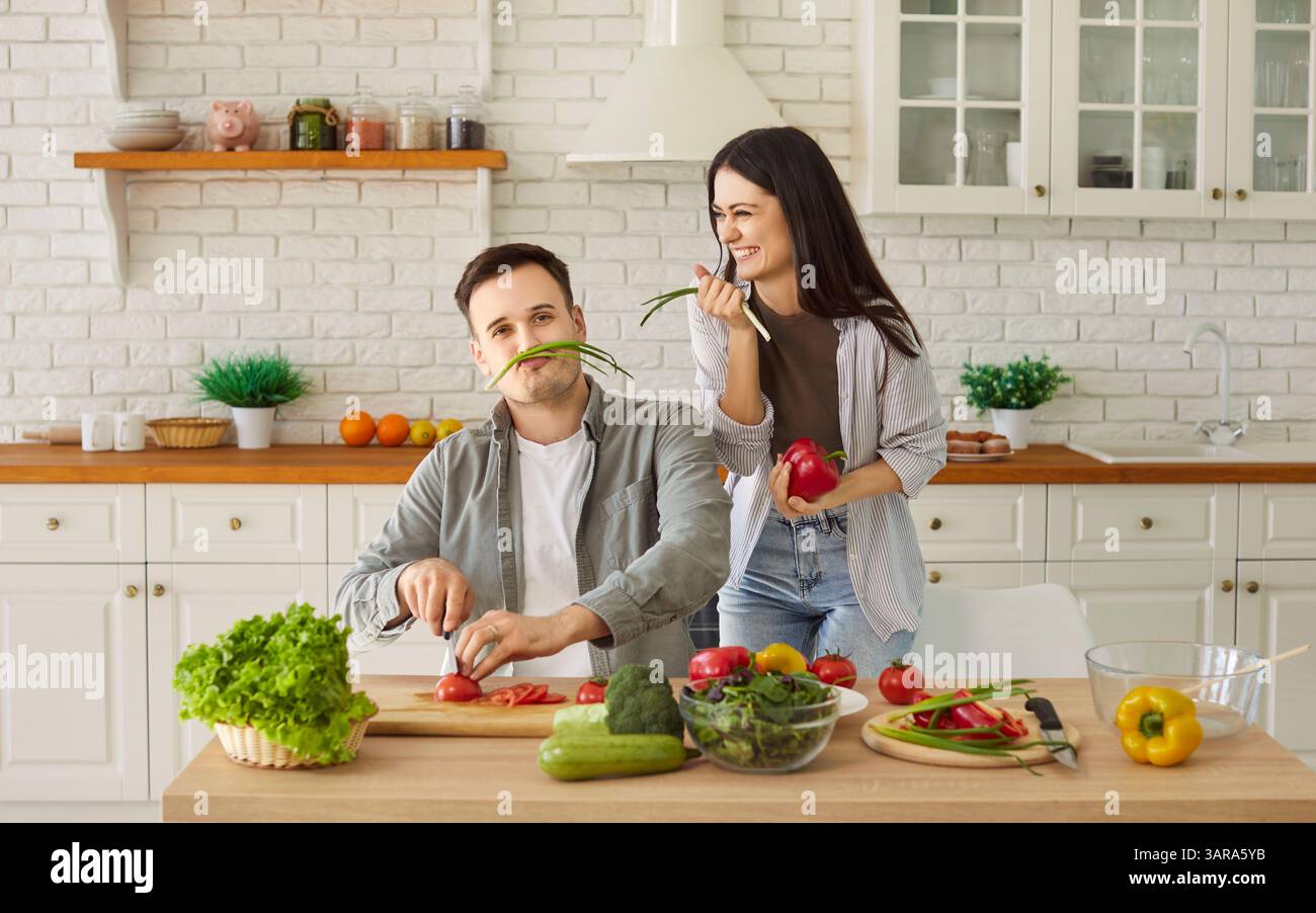 Cheerful Couple Cooking Lunch Together In The Kitchen And Having Fun At Home Stock Photo