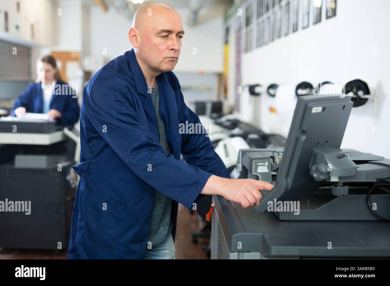 Man working in publishing facility Stock Photo