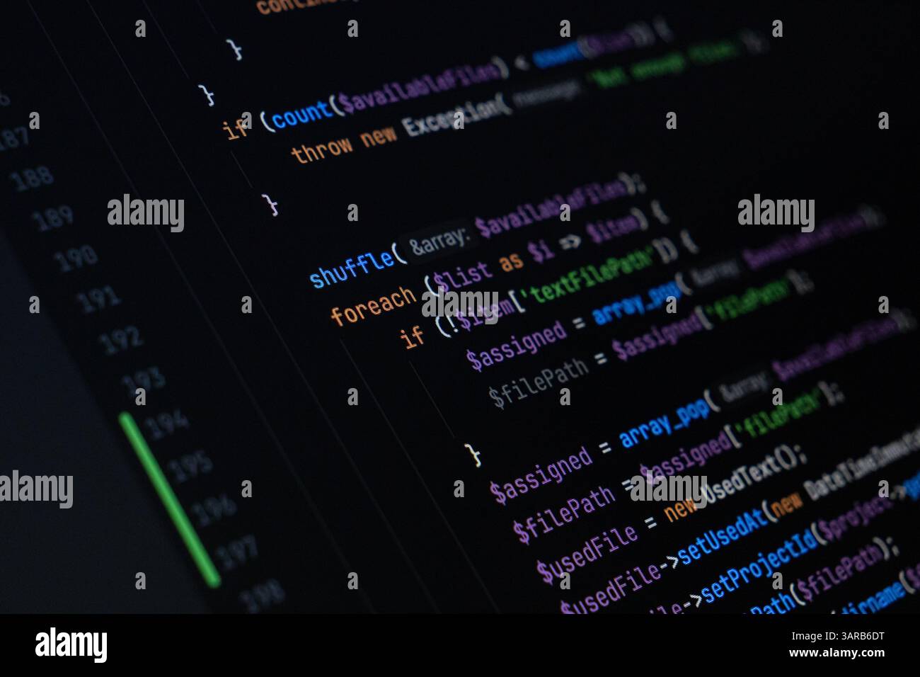 Close-up of PHP code displayed on a dark screen showing loop structures, array manipulation, and conditional logic for file assignment and data proces Stock Photo