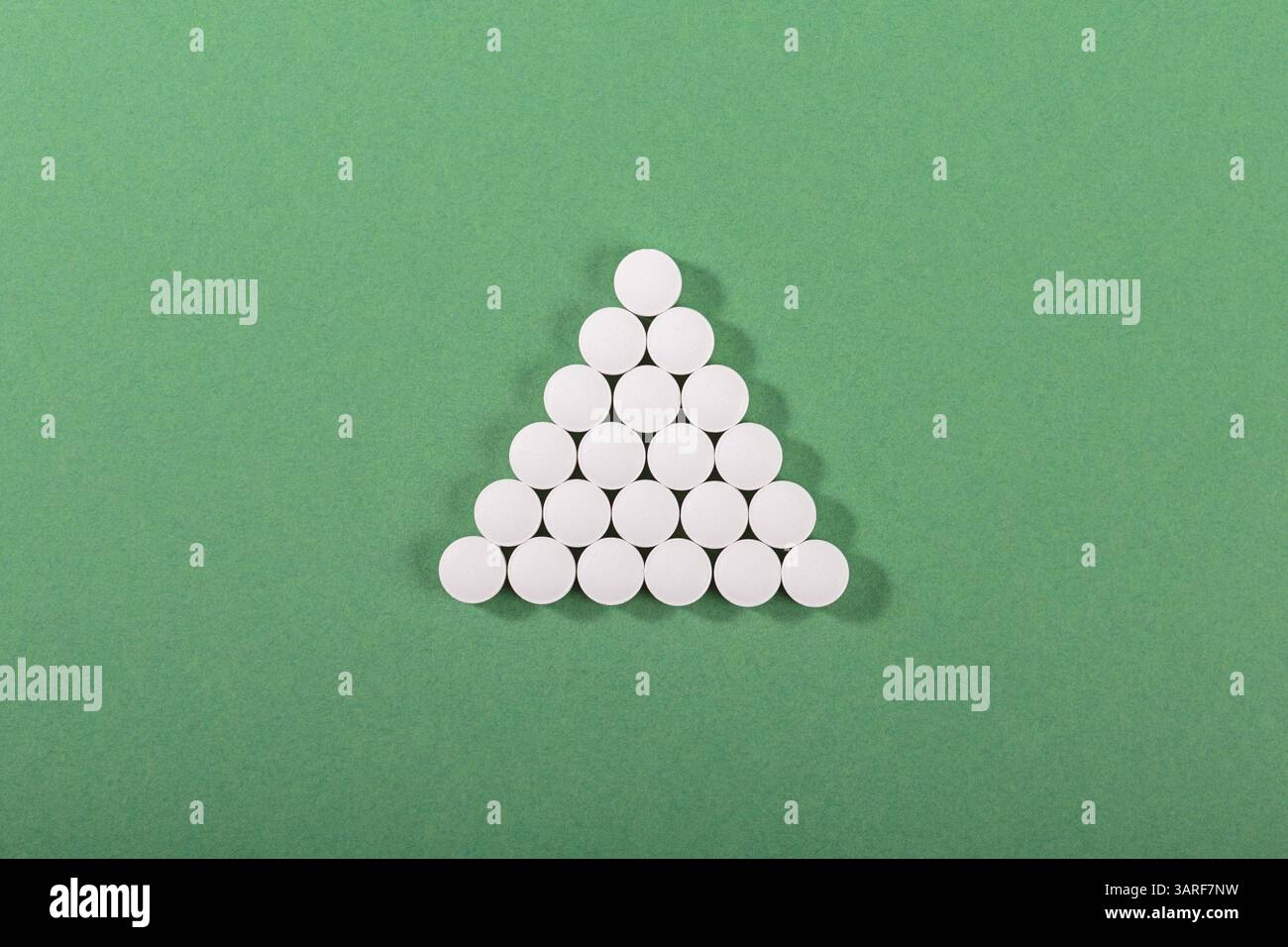 Pyramid Tablet Pyramid of white tablets on green background Stock Photo - Alamy