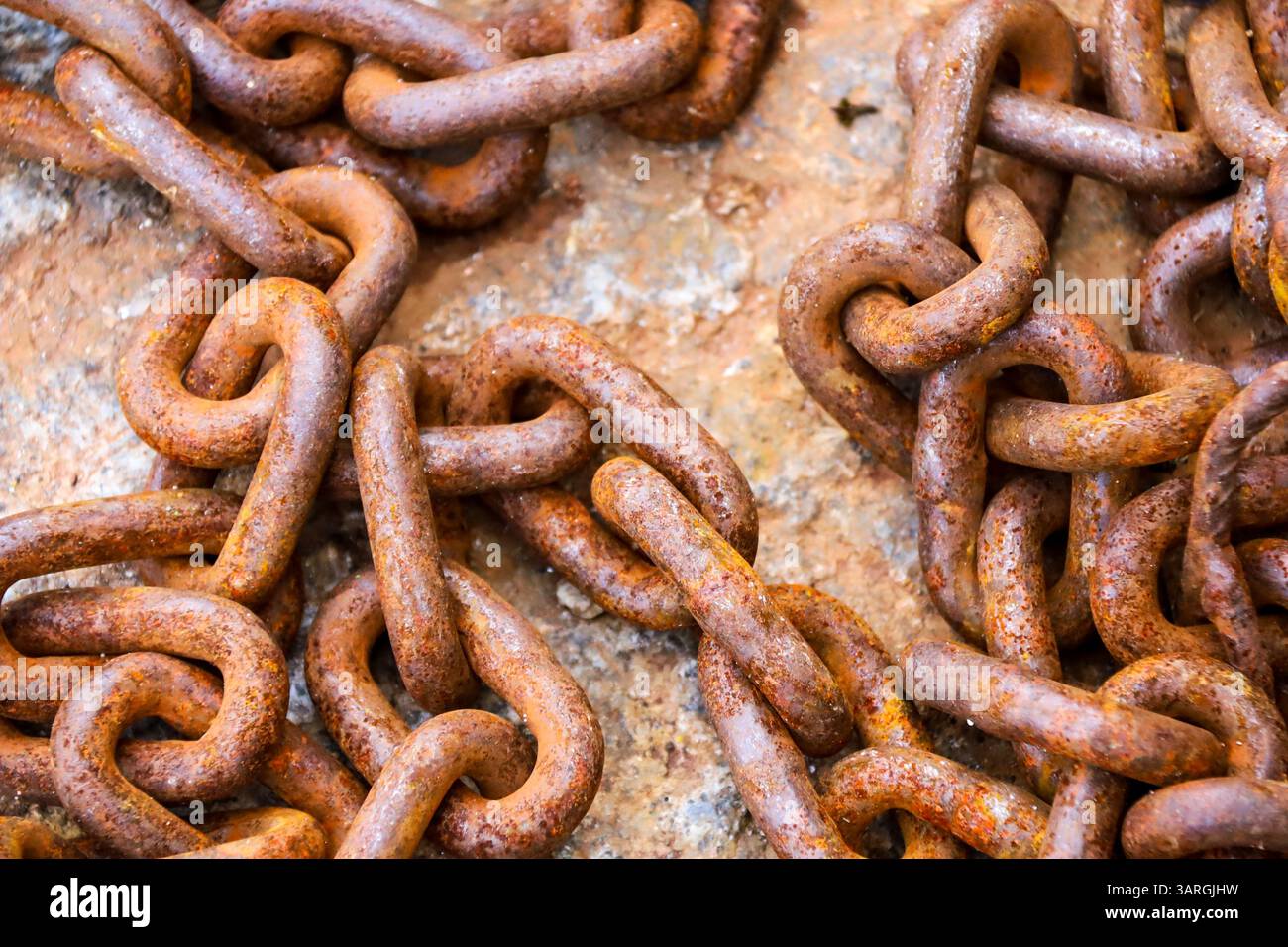Rusty chains on stone floor on the dock in Spain Stock Photo