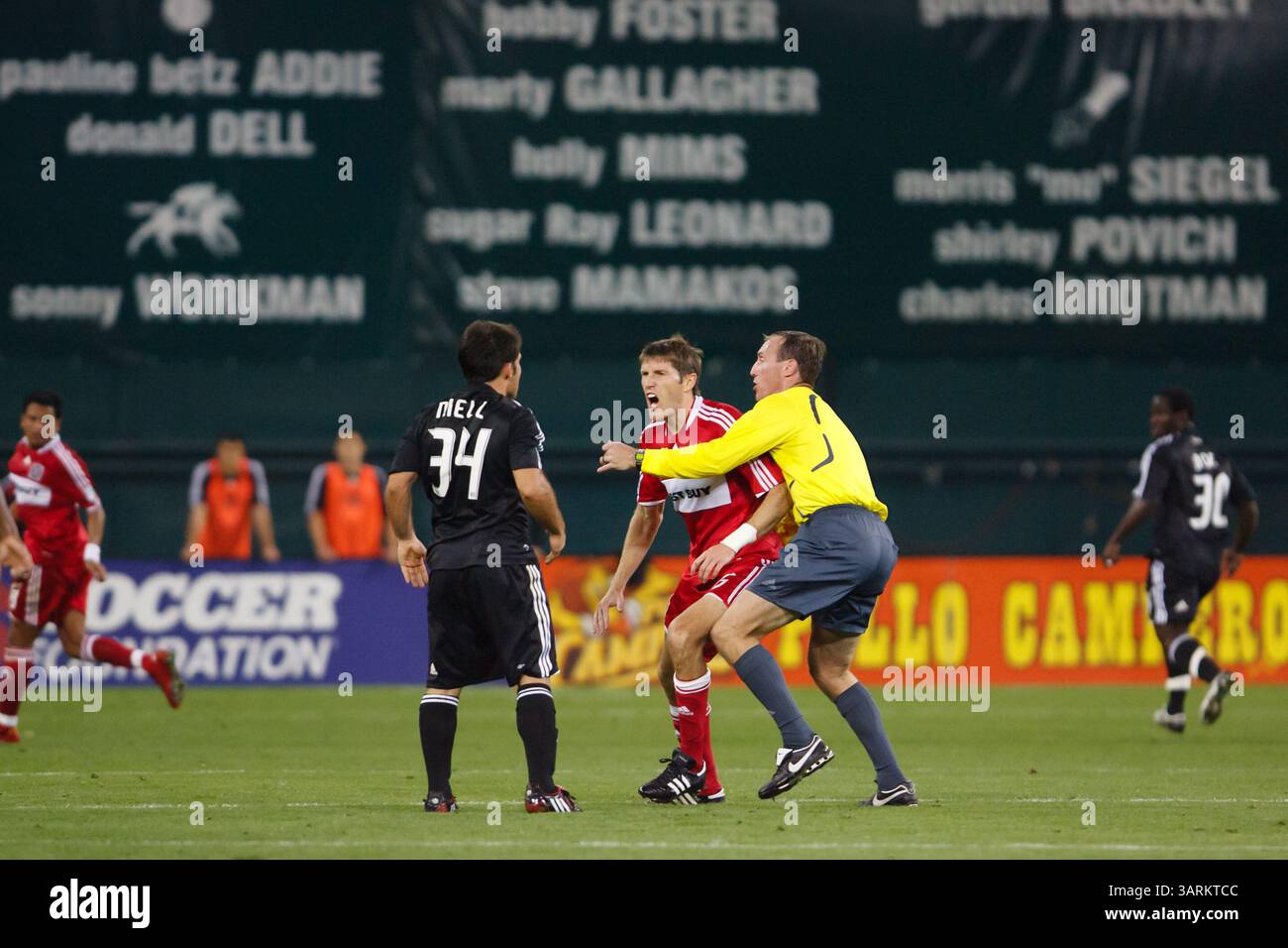 Referee Terry Vaughn separates DC United and Chicago Fire players during a Major League Soccer match on May 8, 2008 at RFK Stadium in Washington, DC. Editorial use only. Commercial use prohibited. Stock Photo