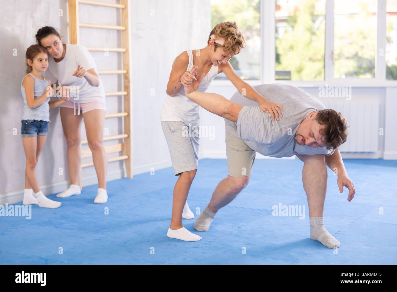 Father teaches his son to use forceful techniques and grips during self ...