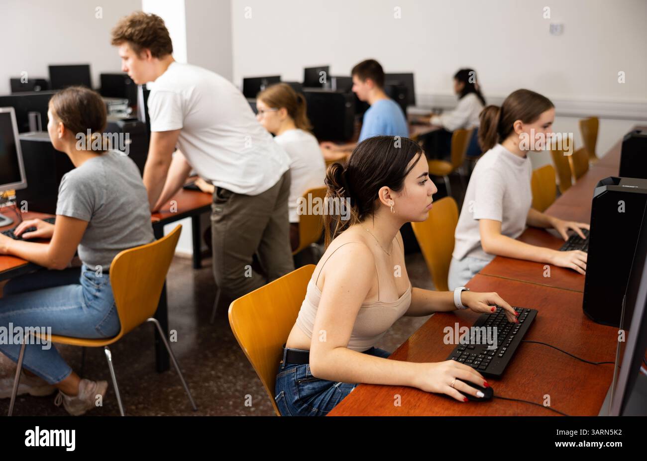 Portrait of interested teen girl during lesson in computer room of ...