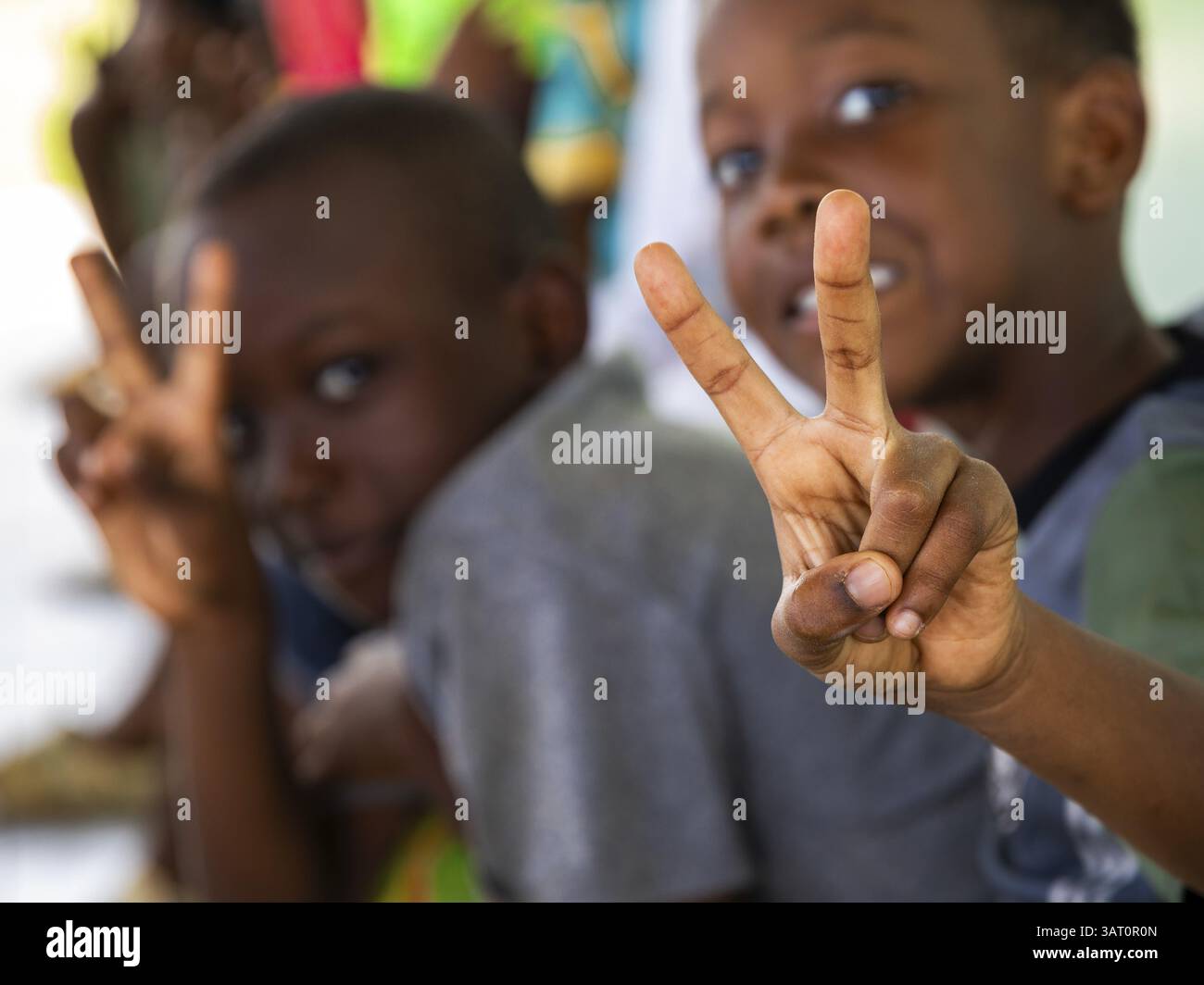 Two boys making a peace sign with their hands. Snapshot. It was taken ...