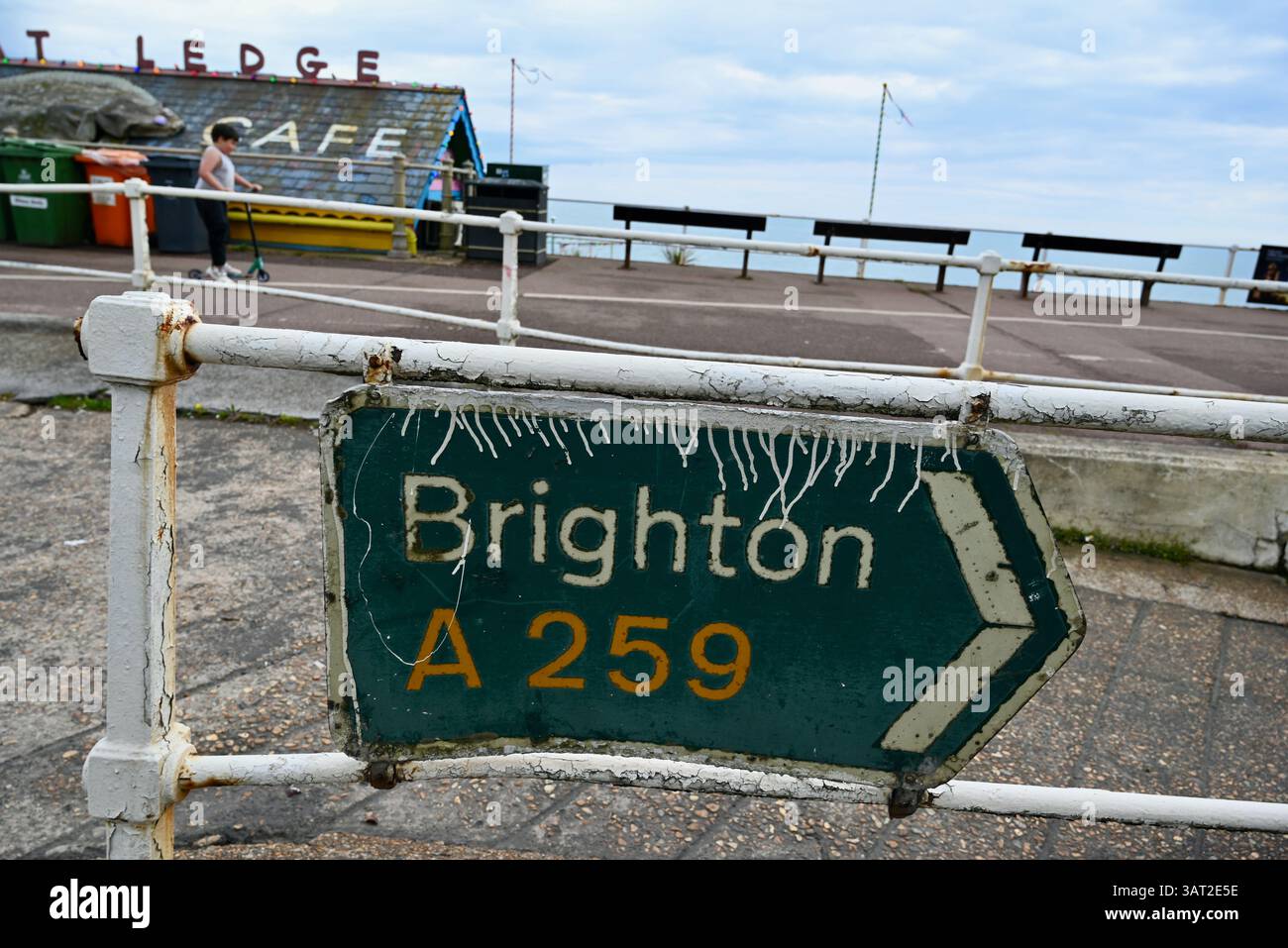 a mangled dirty old road sign directing traffic on to the A259 to ...