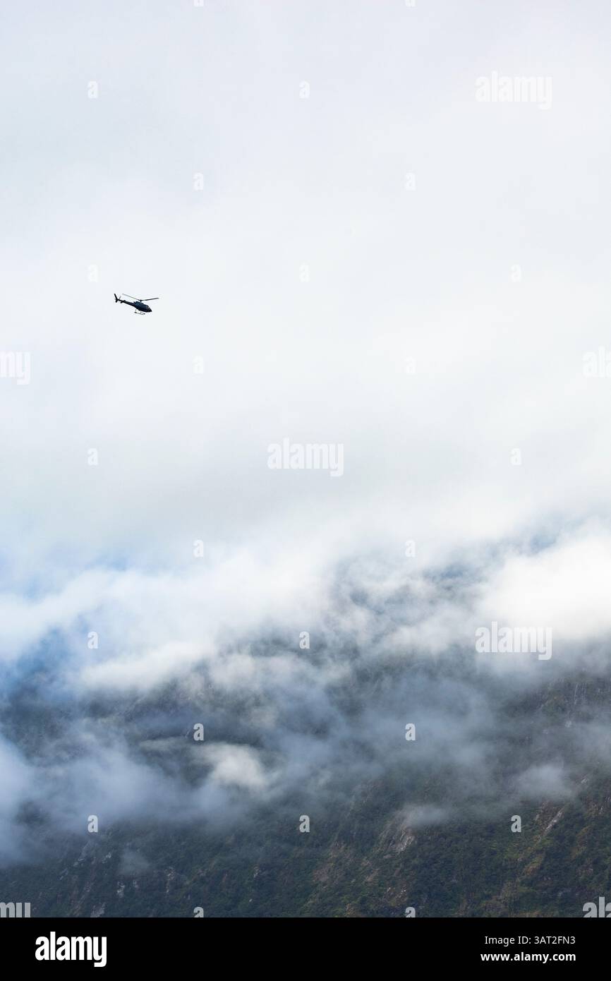 Helicopter over Milford Sound, New Zealand Stock Photo