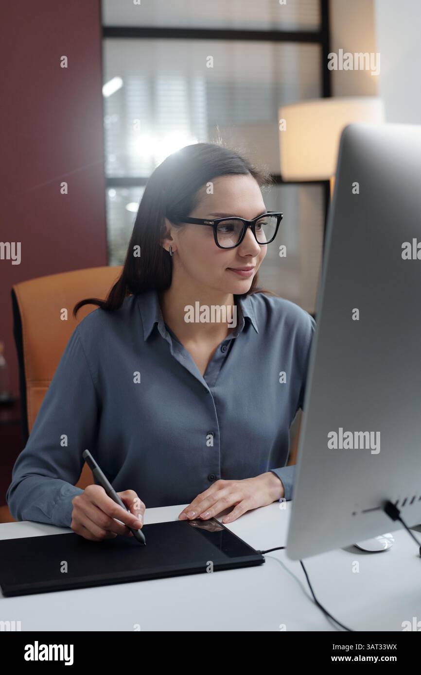 Smiling Woman using Drawing Tablet in Office Stock Photo